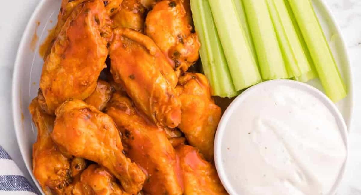 Buffalo chicken wings on white plate that was made in the instant pot with air fryer lid.