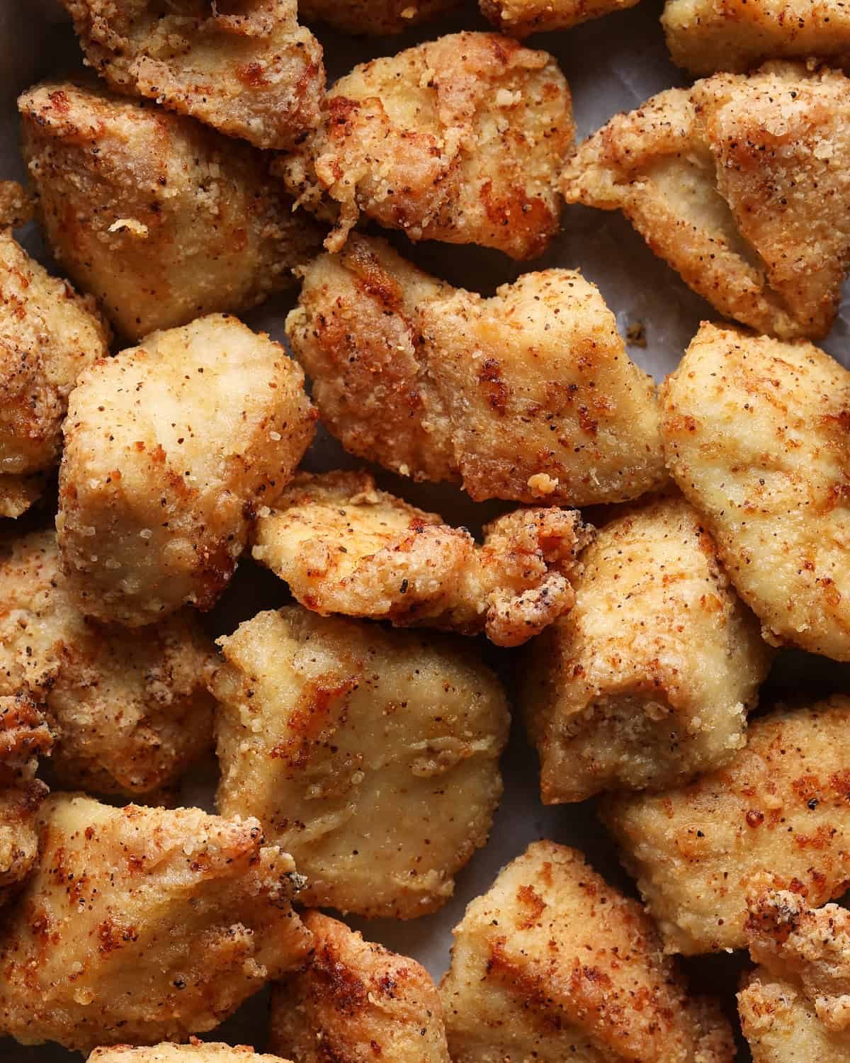 Close-up of crispy air fryer chicken bites seasoned with seasoned salt.
