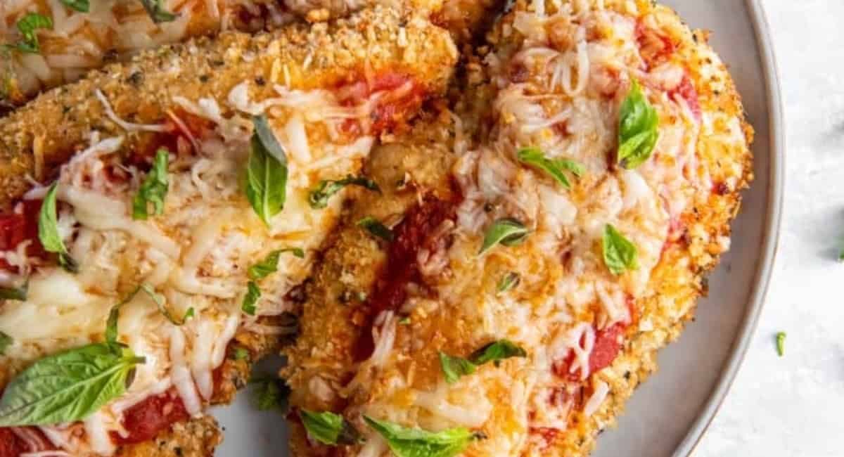 Overhead image of air fryer chicken parmesan with garnish.