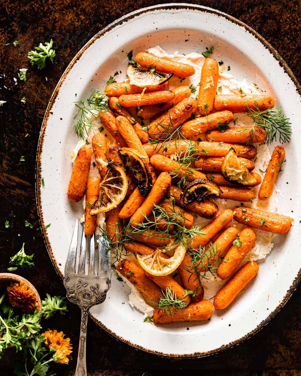 overhead of air fryer baby carrots over feta topped with dill