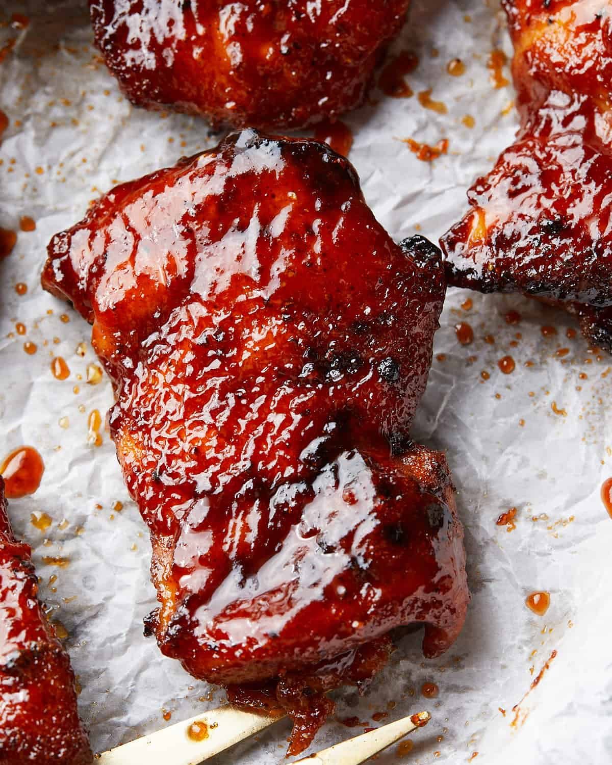 Up close image of air fryer bbq chicken thigh with bbq sauce.