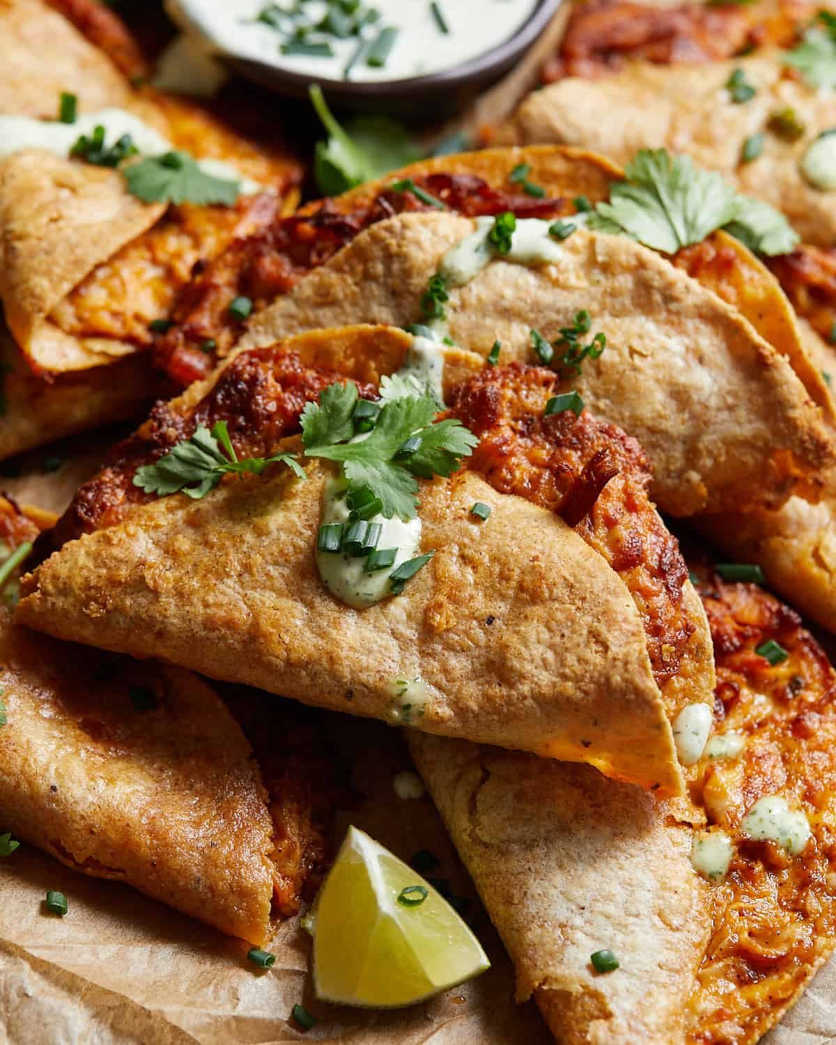 Air fryer buffalo chicken tacos with ranch drizzled on top.