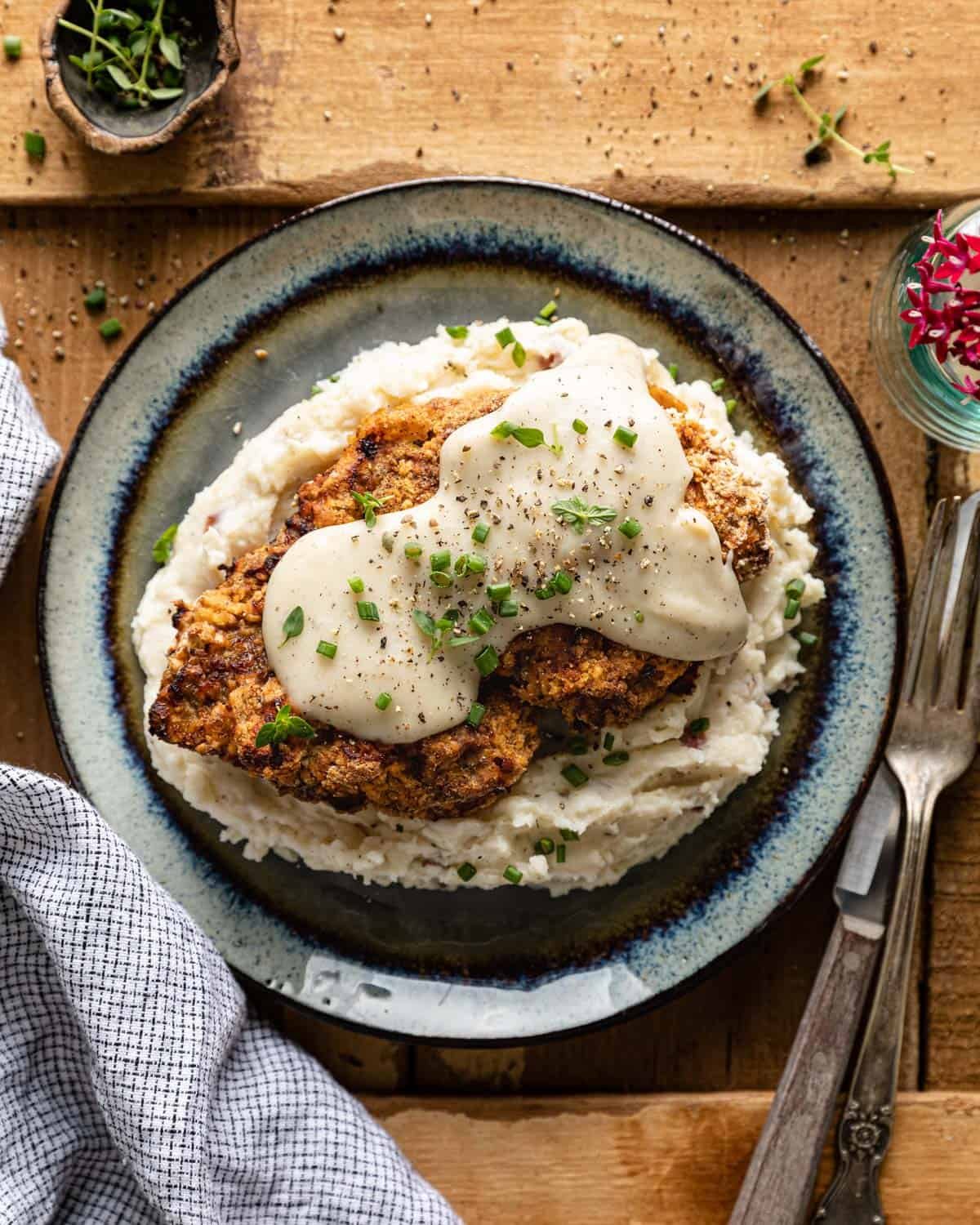 Air fryer chicken fried steak on a bed of mashed potatoes.