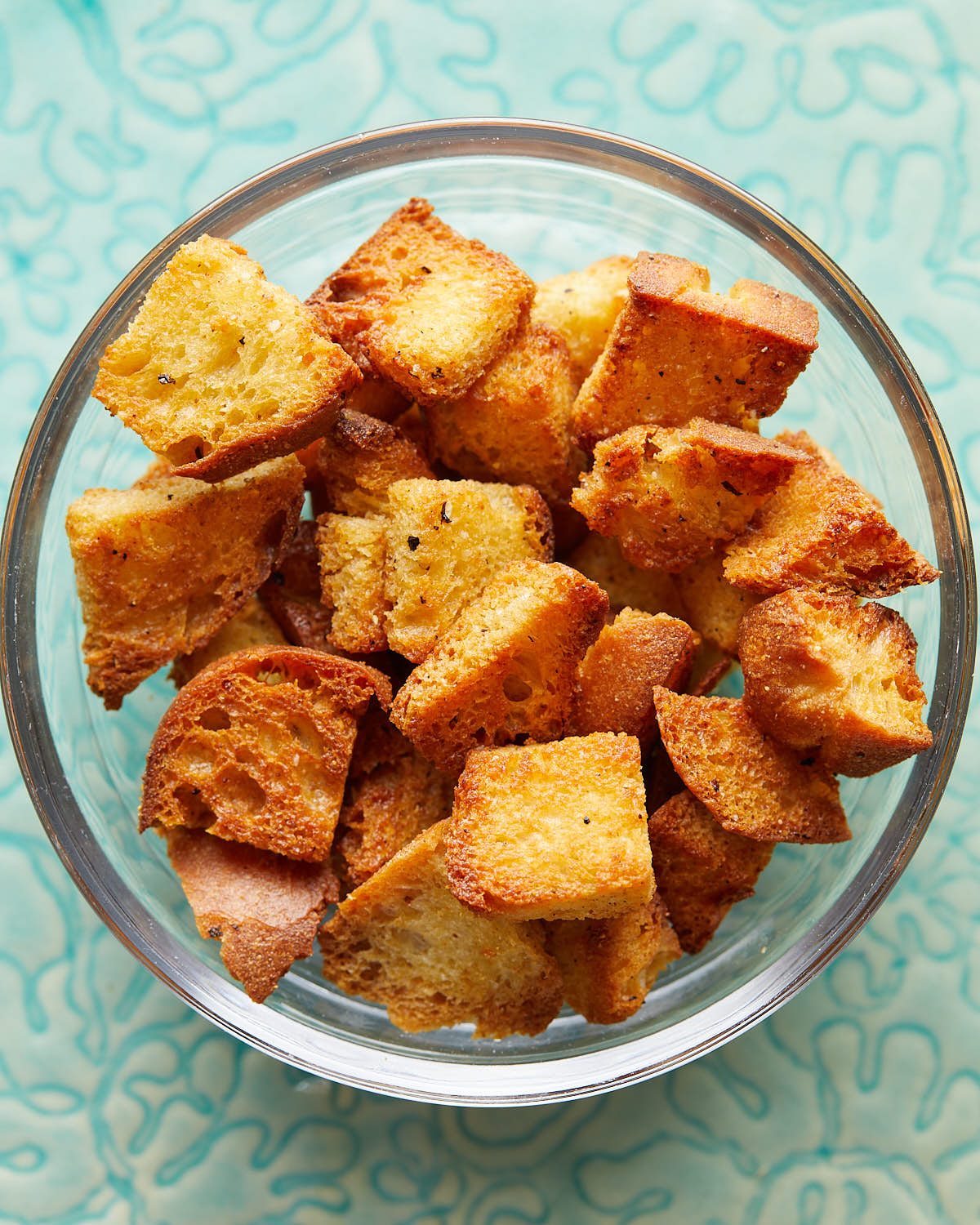 Overhead image of air fryer croutons in clear bowl.