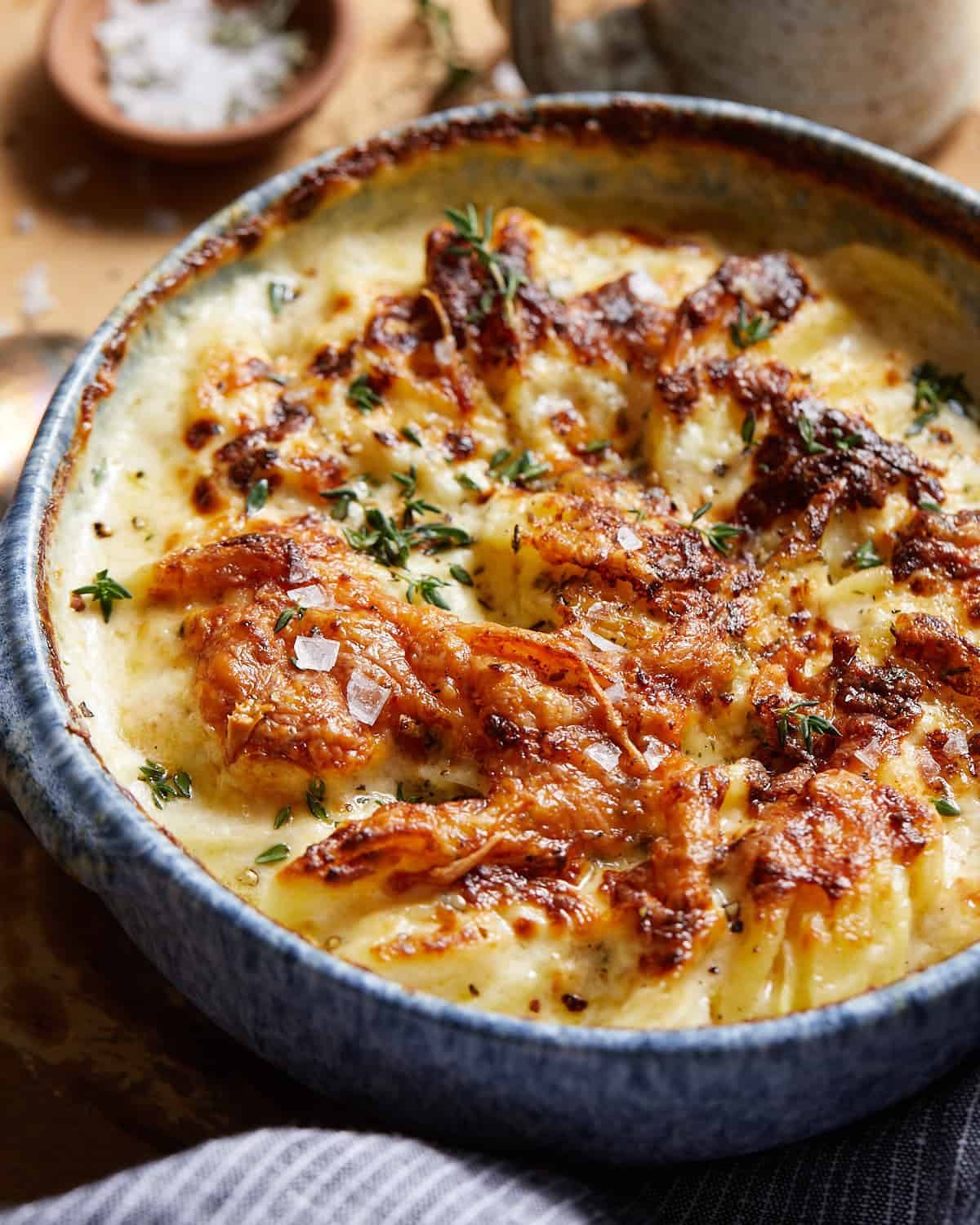 Air fryer scalloped potatoes with thyme and salt on top.
