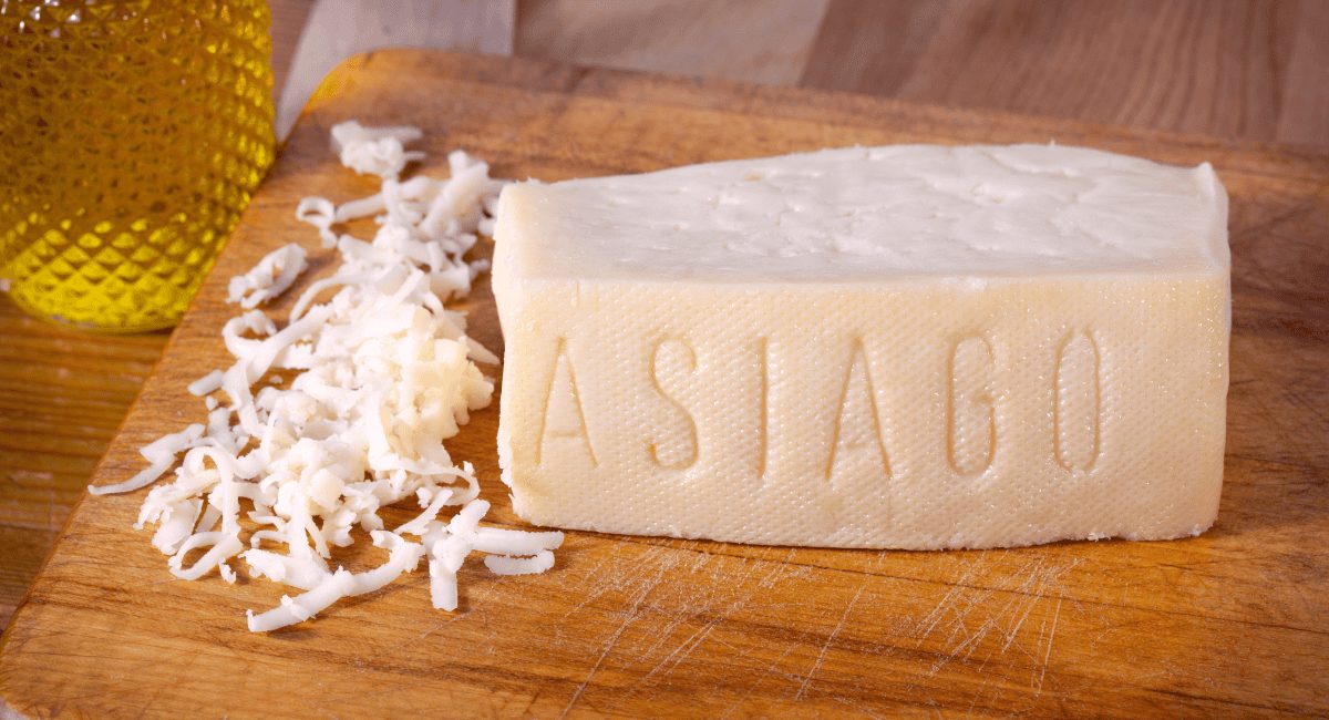 Up close image of Asiago cheese (grated and block).