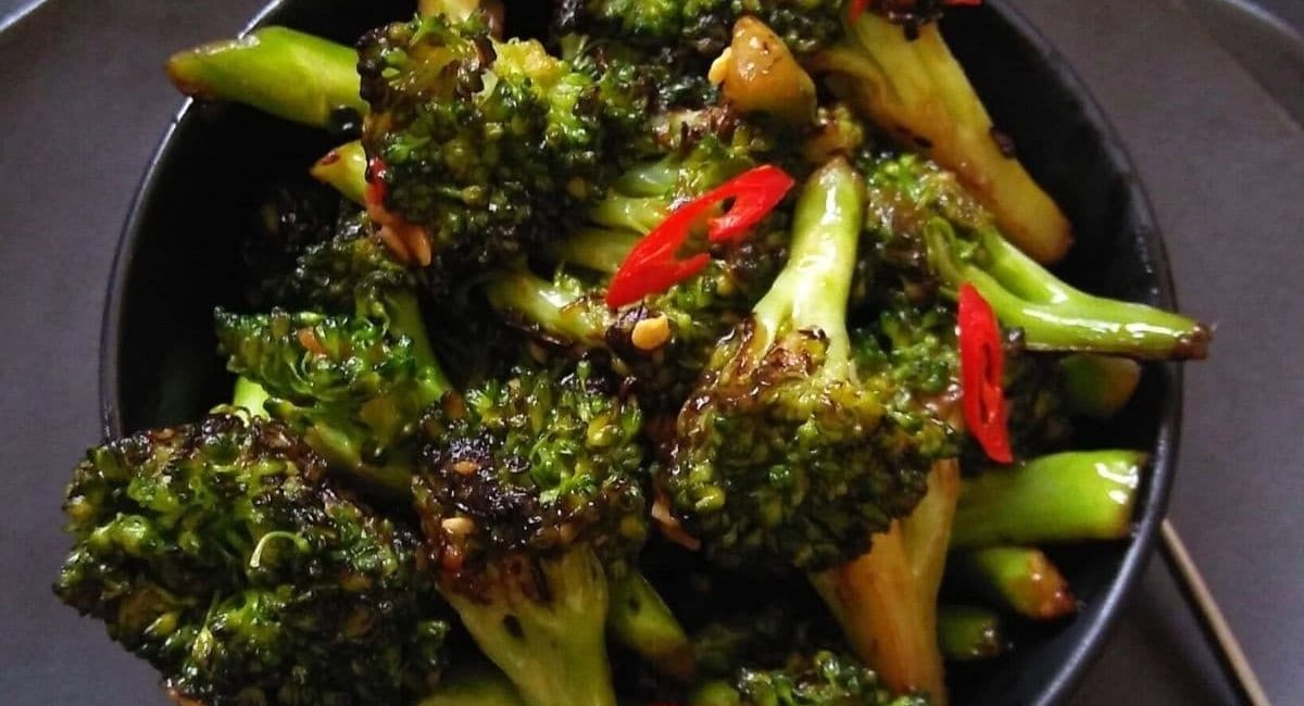 Overhead image of Asian broccoli stir fry in black bowl.