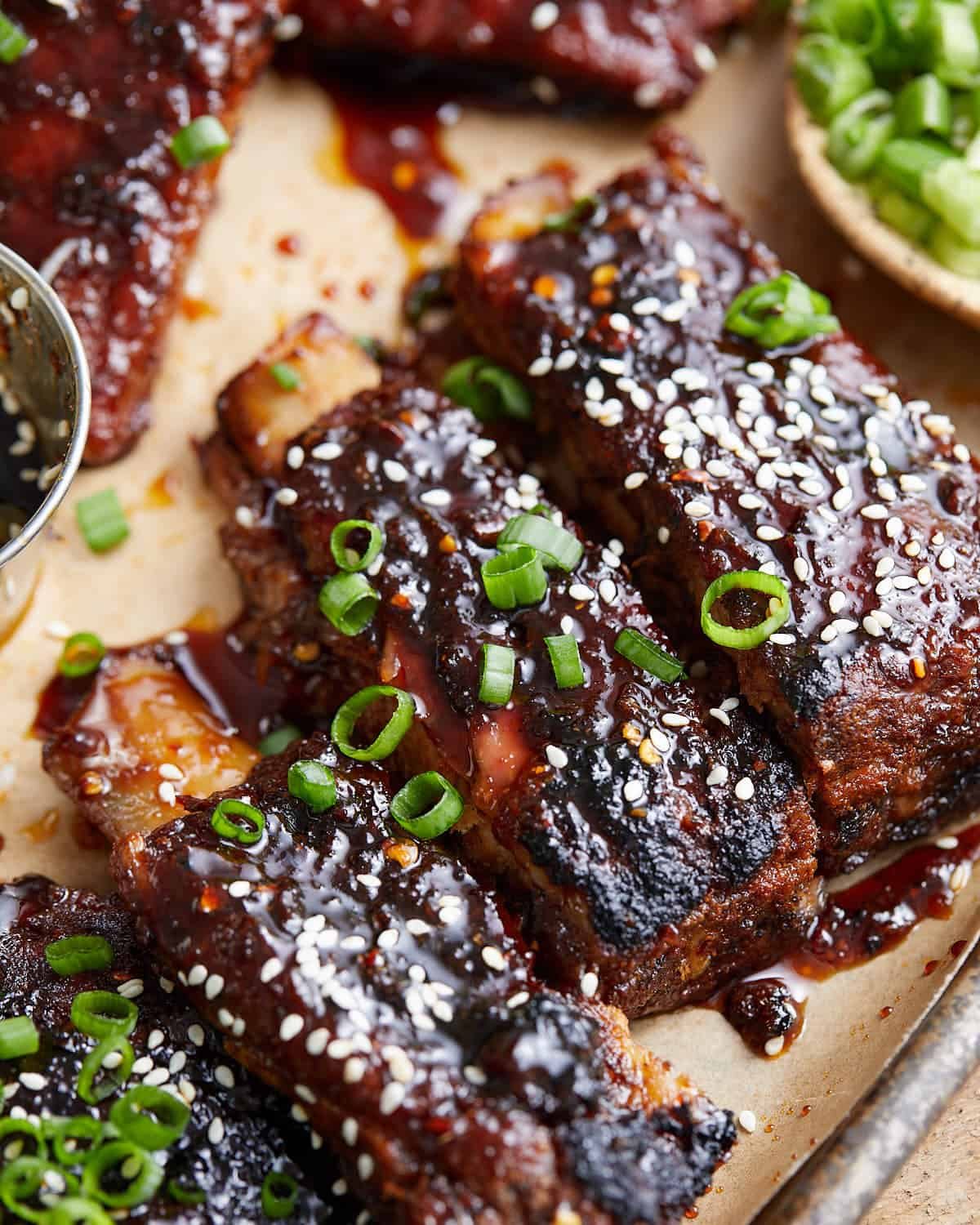 Up close image of sticky asian ribs with garnish.