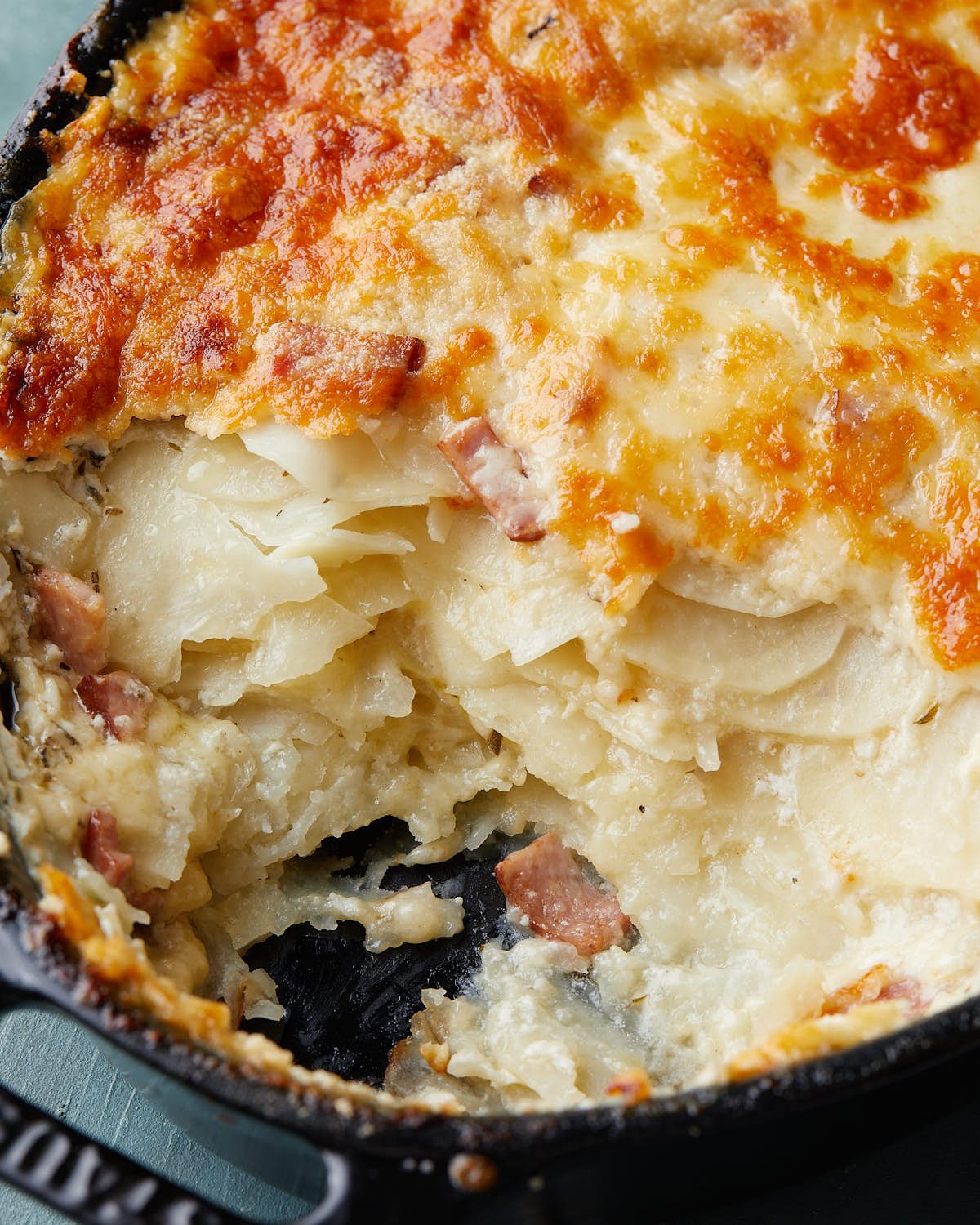 Up close image of au gratin potatoes with ham.