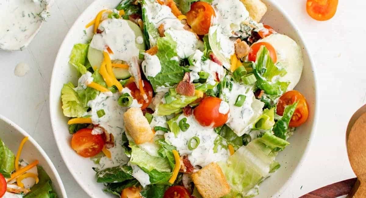 Overhead image of side salad on white dish with garnish.