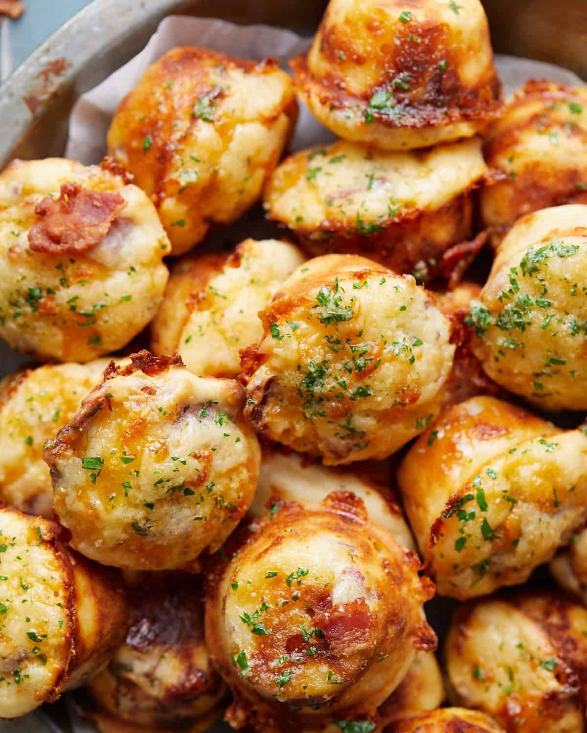 Overhead image of bacon and cheddar cheese muffins with garnish.