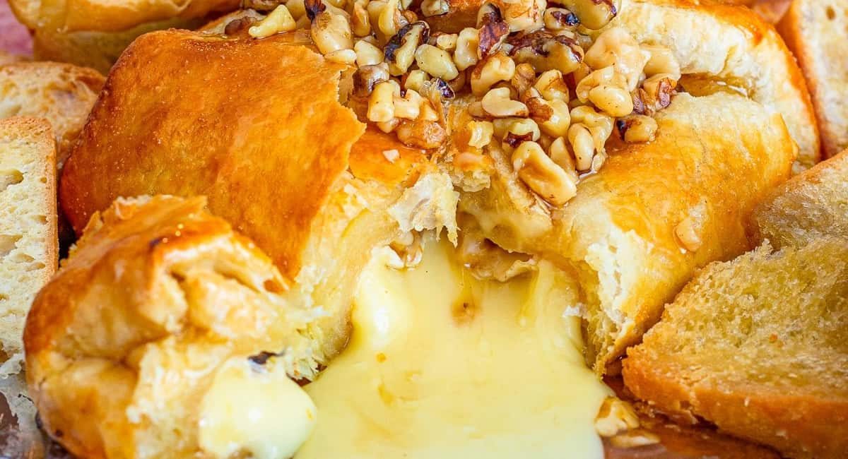 Up close image of baked brie in puff pastry with walnuts and honey.