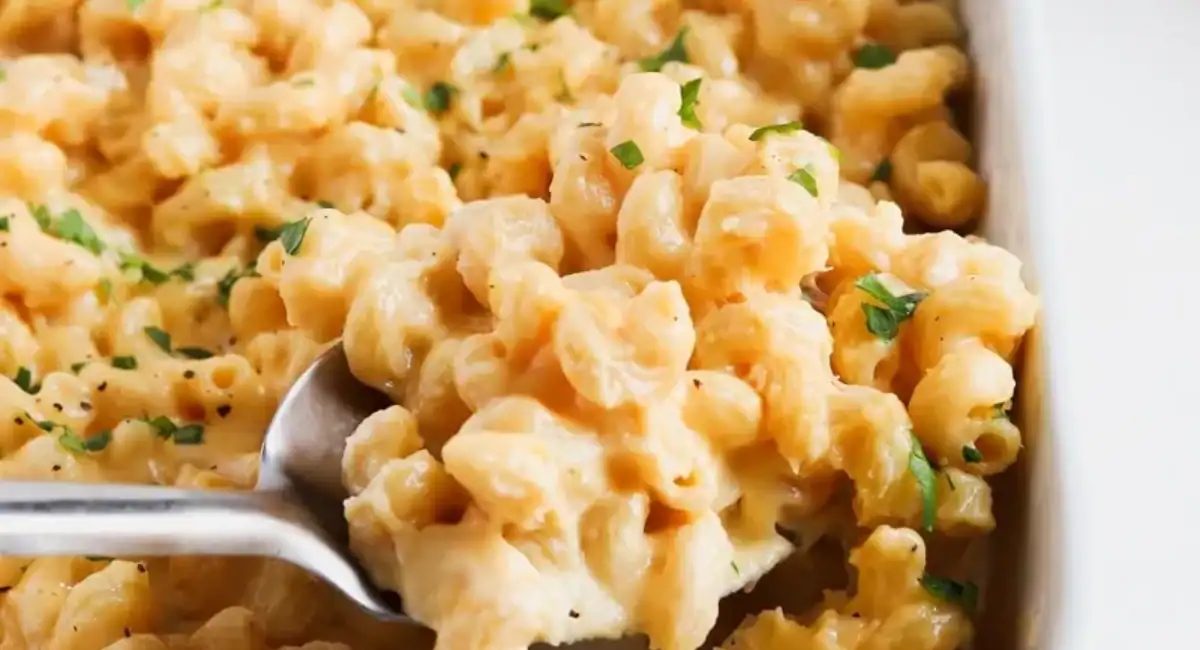 Up close image of creamy baked cavatappi mac and cheese in white dish.