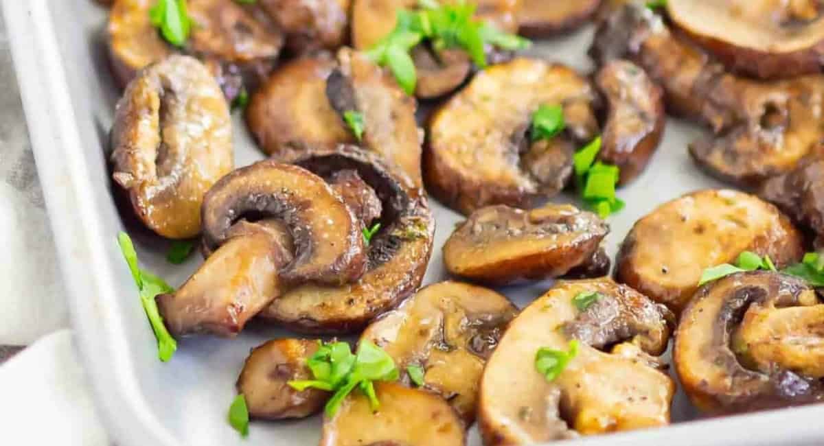 Up close image of baked ranch mushrooms with garnish.
