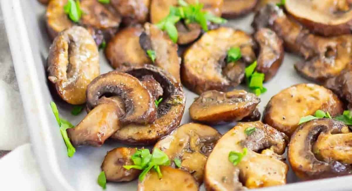 Overhead image of baked ranch mushrooms with garnish.