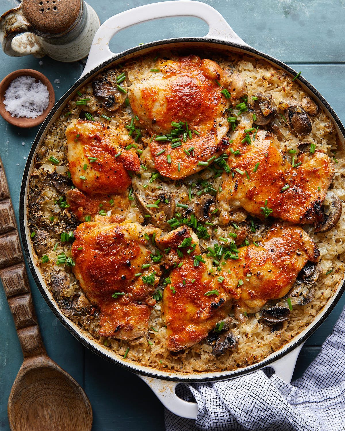 Overhead image of oven baked chicken and rice in white pot.