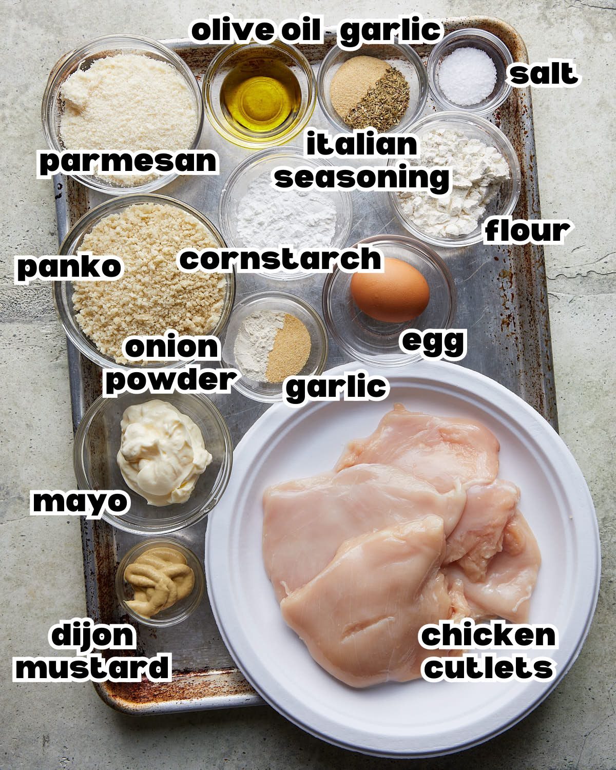 Labeled ingredients for crispy baked chicken cutlets, including chicken, panko, Parmesan, flour, cornstarch, mayonnaise, egg, Dijon mustard, olive oil, and seasonings.