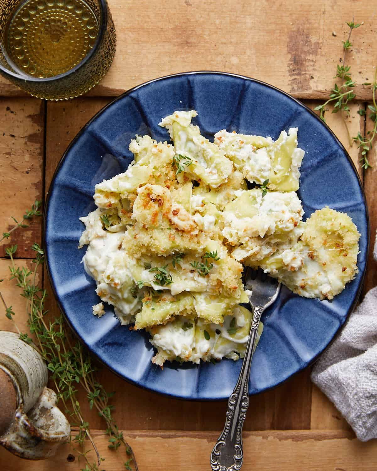 Overhead image of baked tortellini alfredo on blue dish.