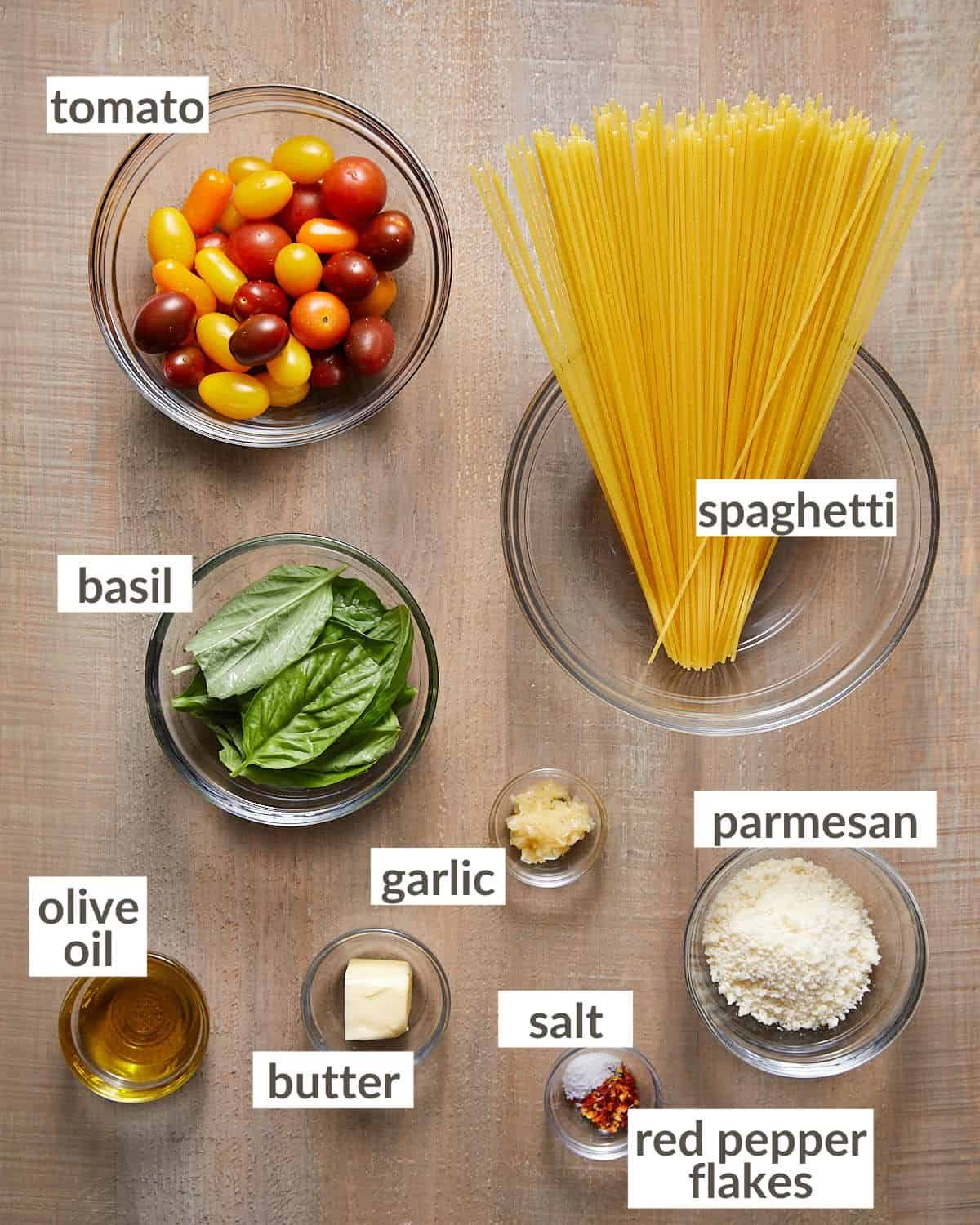 Ingredients needed to make tomato basil pasta in glass bowls.