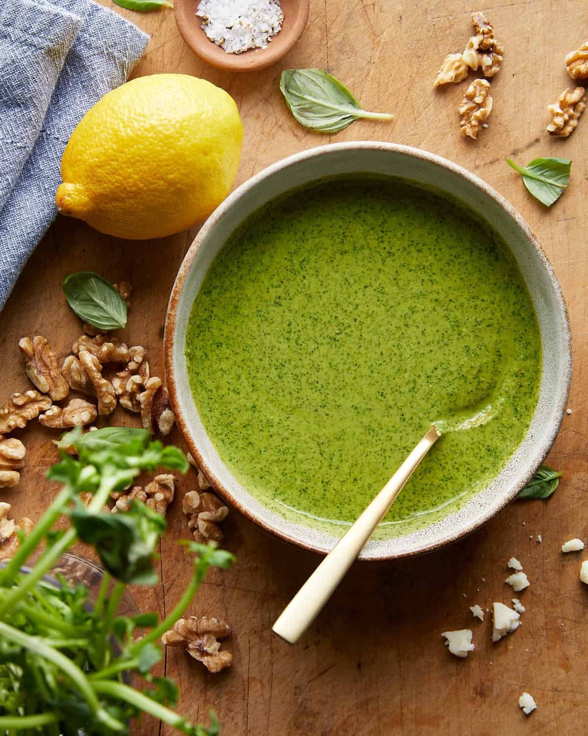 Overhead image of pesto without pine nuts in small bowl with spoon.