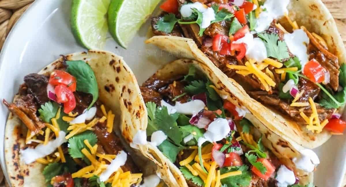 Overhead image of bbq brisket tacos with garnish.