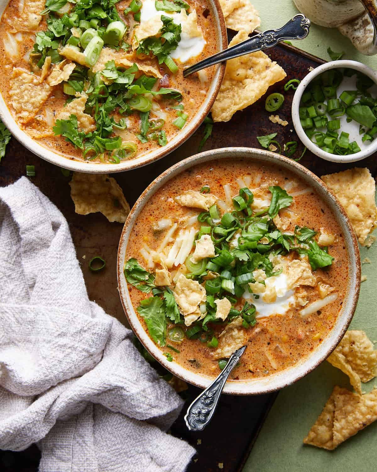 Overhead image of beef enchilada soup with toppings.