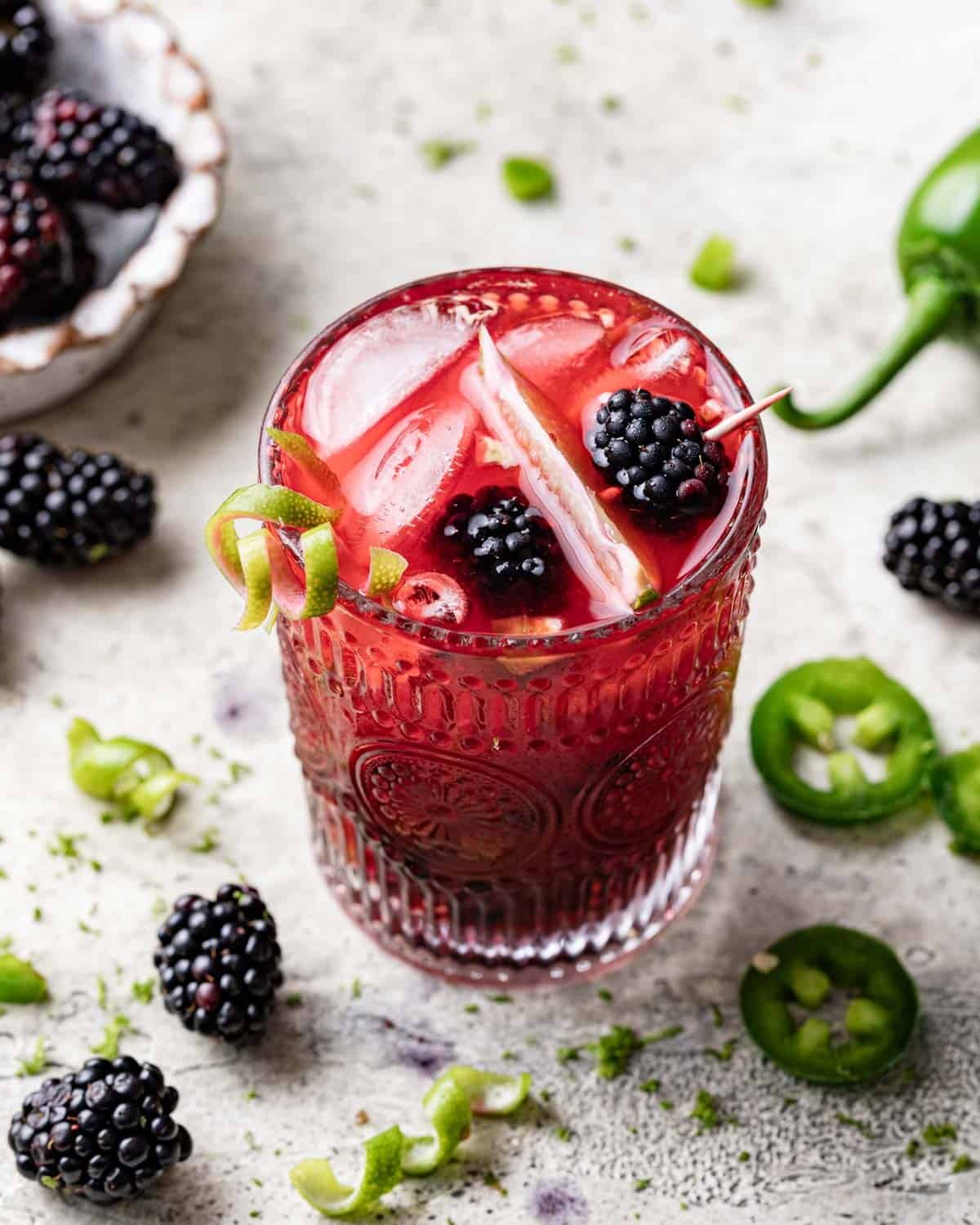 Overhead image. of a blackberry jalapeno margarita with garnish.