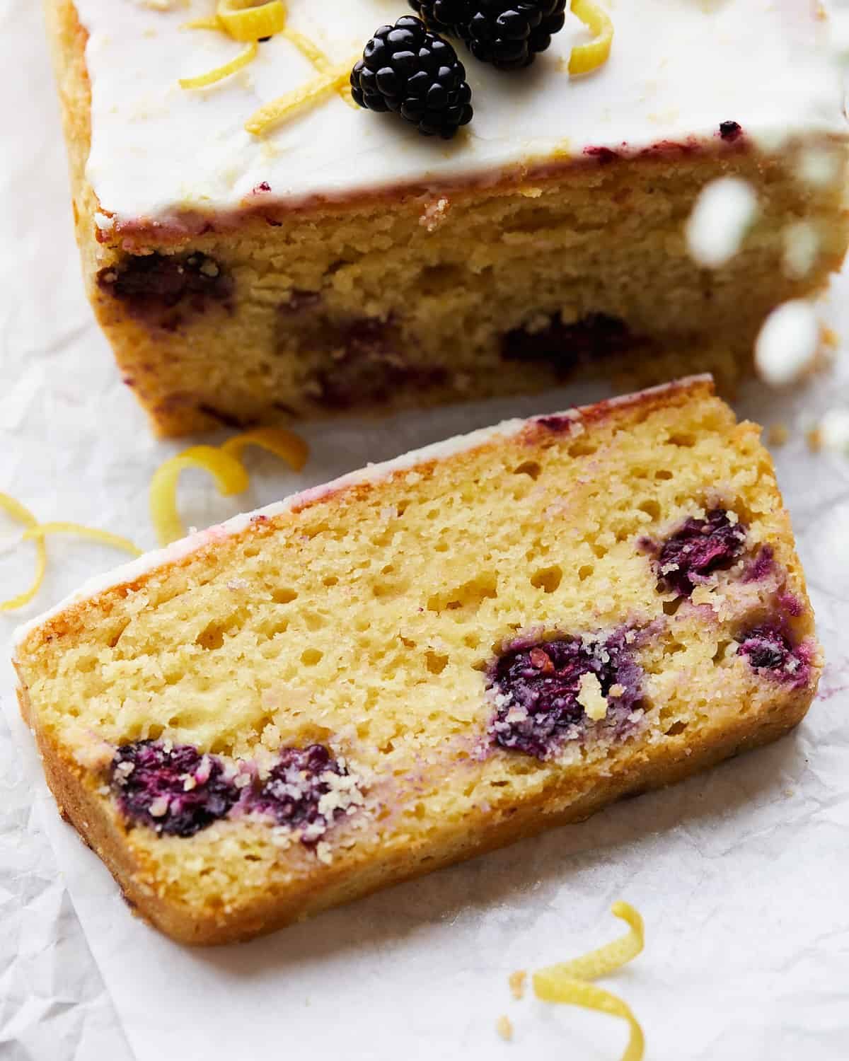 Slice on lemon blackberry bread on parchment paper.