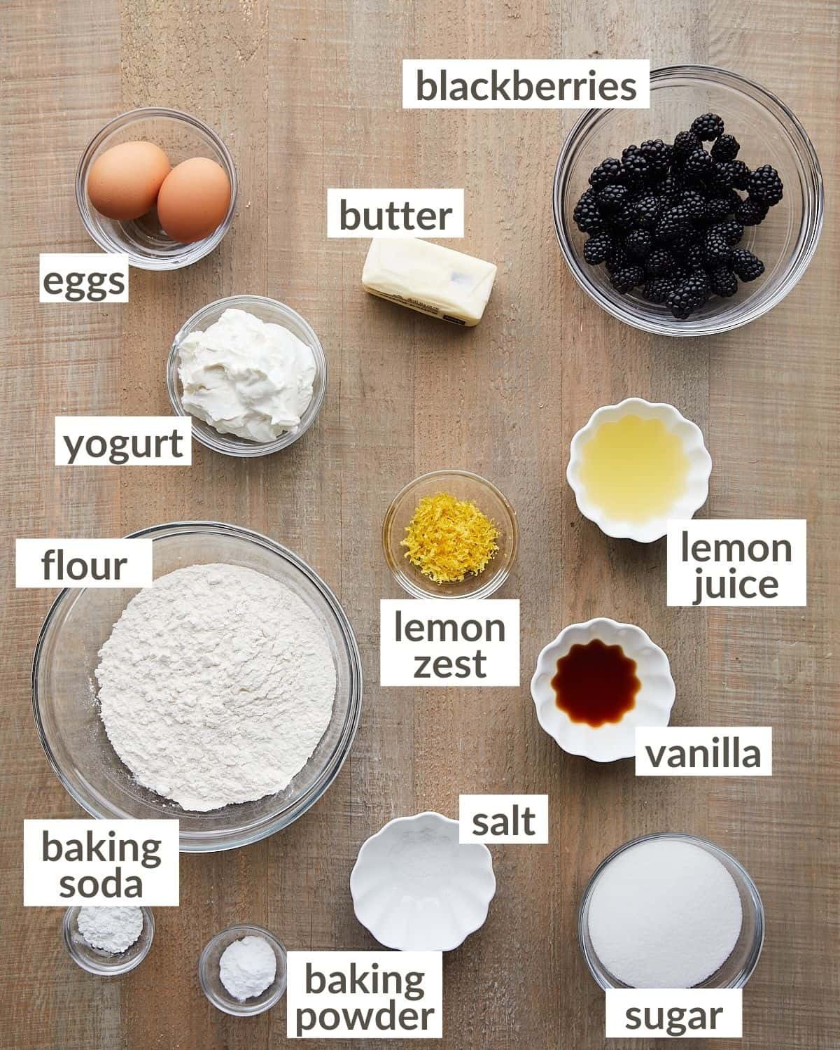 Overhead shot of ingredients in bowls to make blackberry lemon bread loaf.