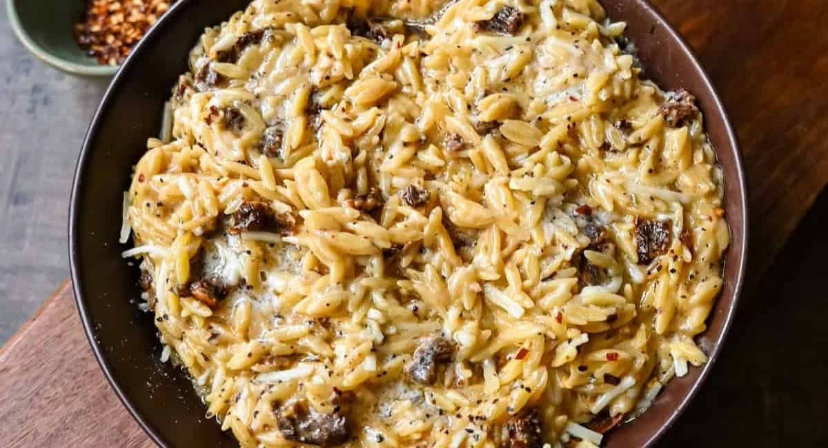 Overhead image of Boursin cheese sundried tomato orzo in brown bowl.