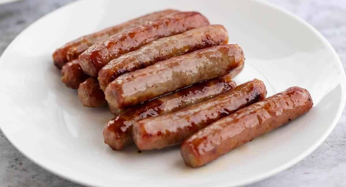 Up close image of breakfast sausage on white dish.