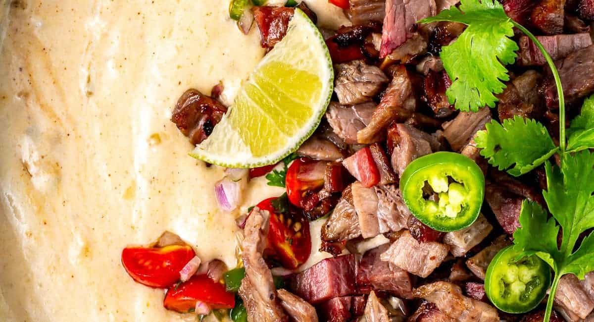 Overhead image of brisket queso with garnish.