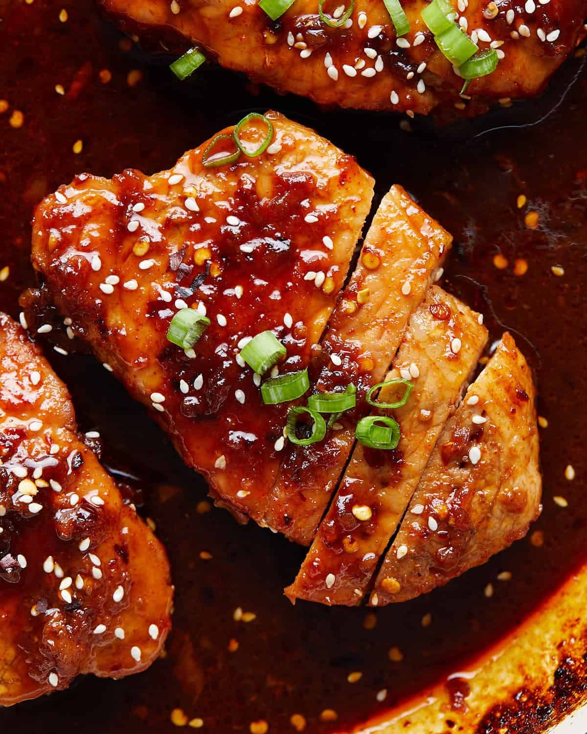 Up close image of brown sugar garlic pork chop with garnish.
