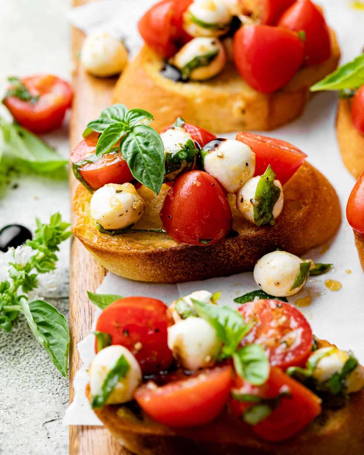 Mozzarella bruschetta with balsamic glaze and basil on top.