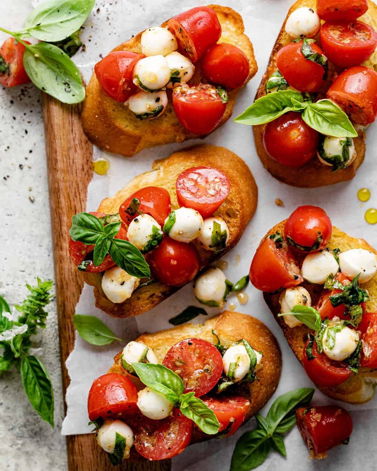 Bruschetta with mozzarella on crostini with basil on top.
