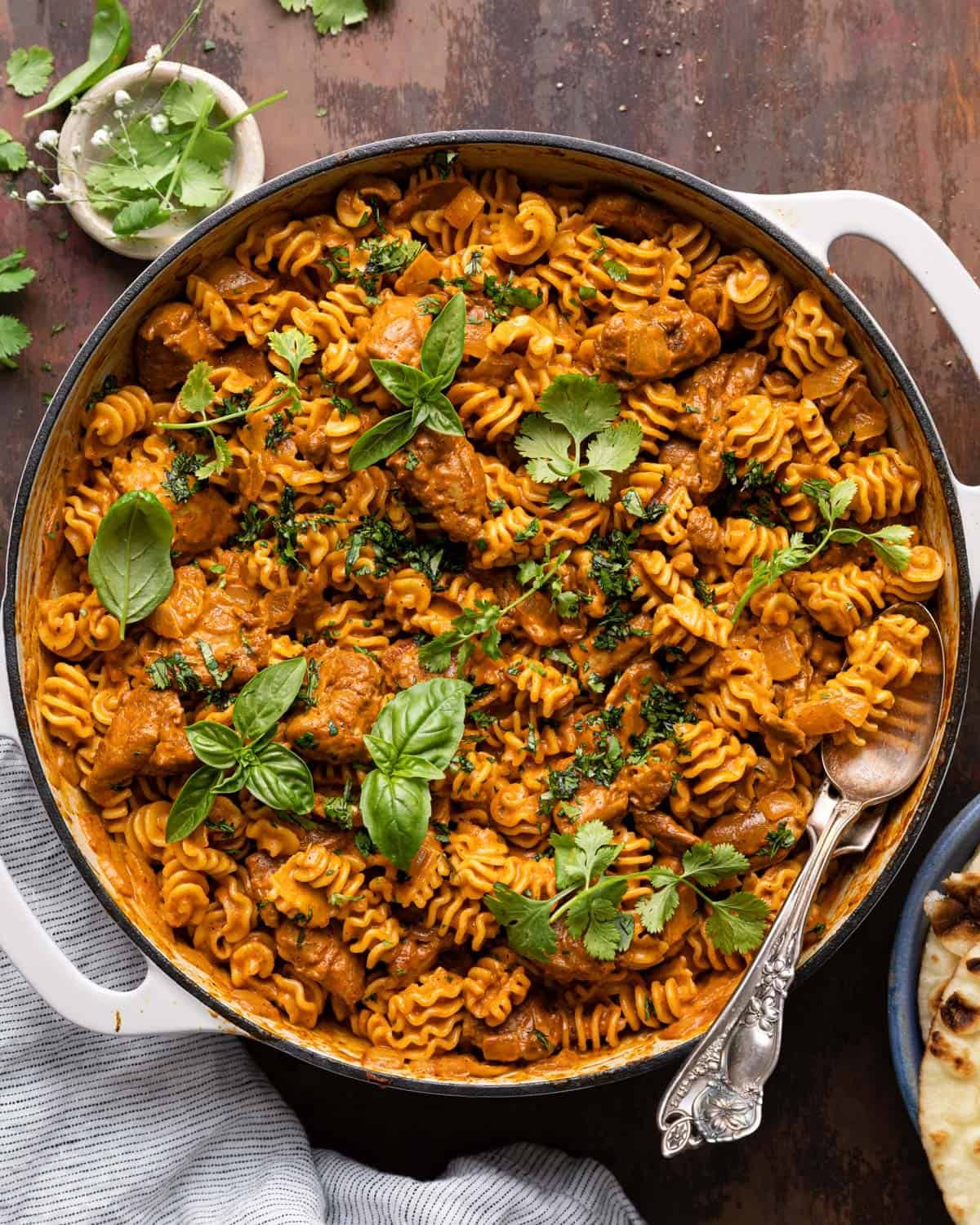 Overhead image of butter chicken pasta in white pan.