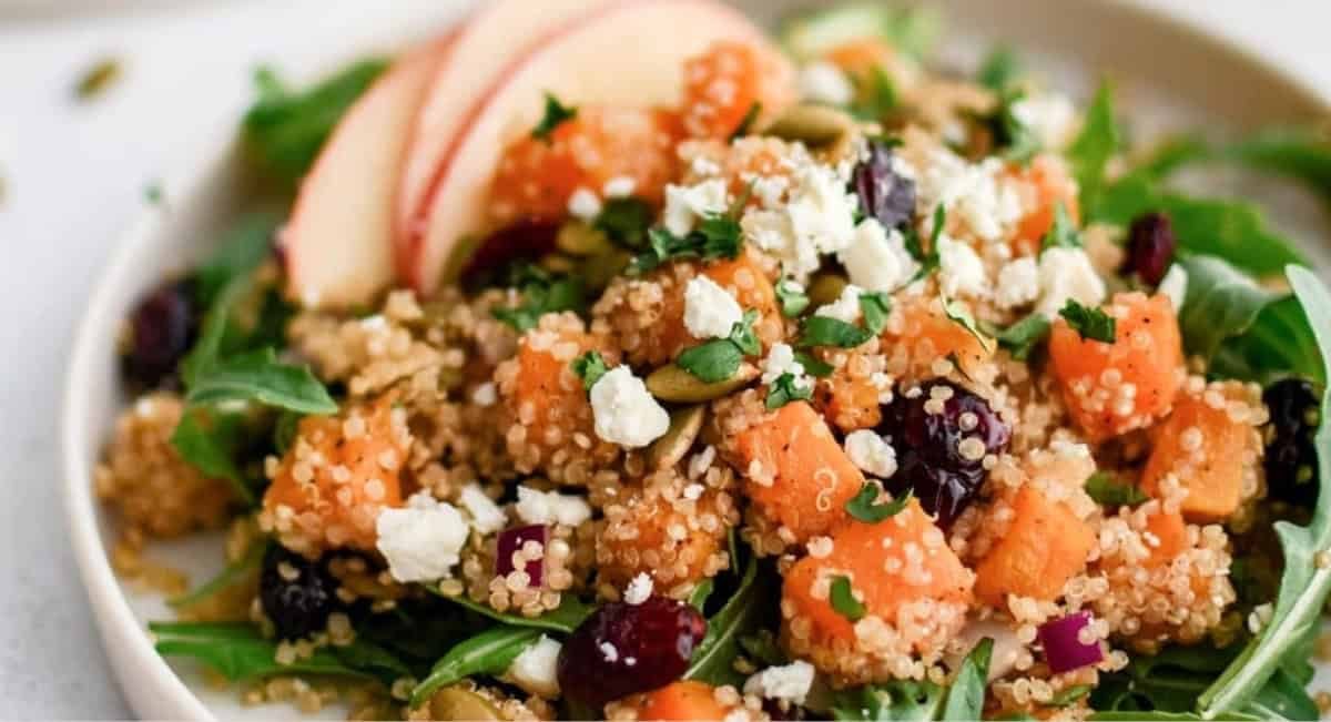 Overhead image of butternut squash salad with garnish on white plate.