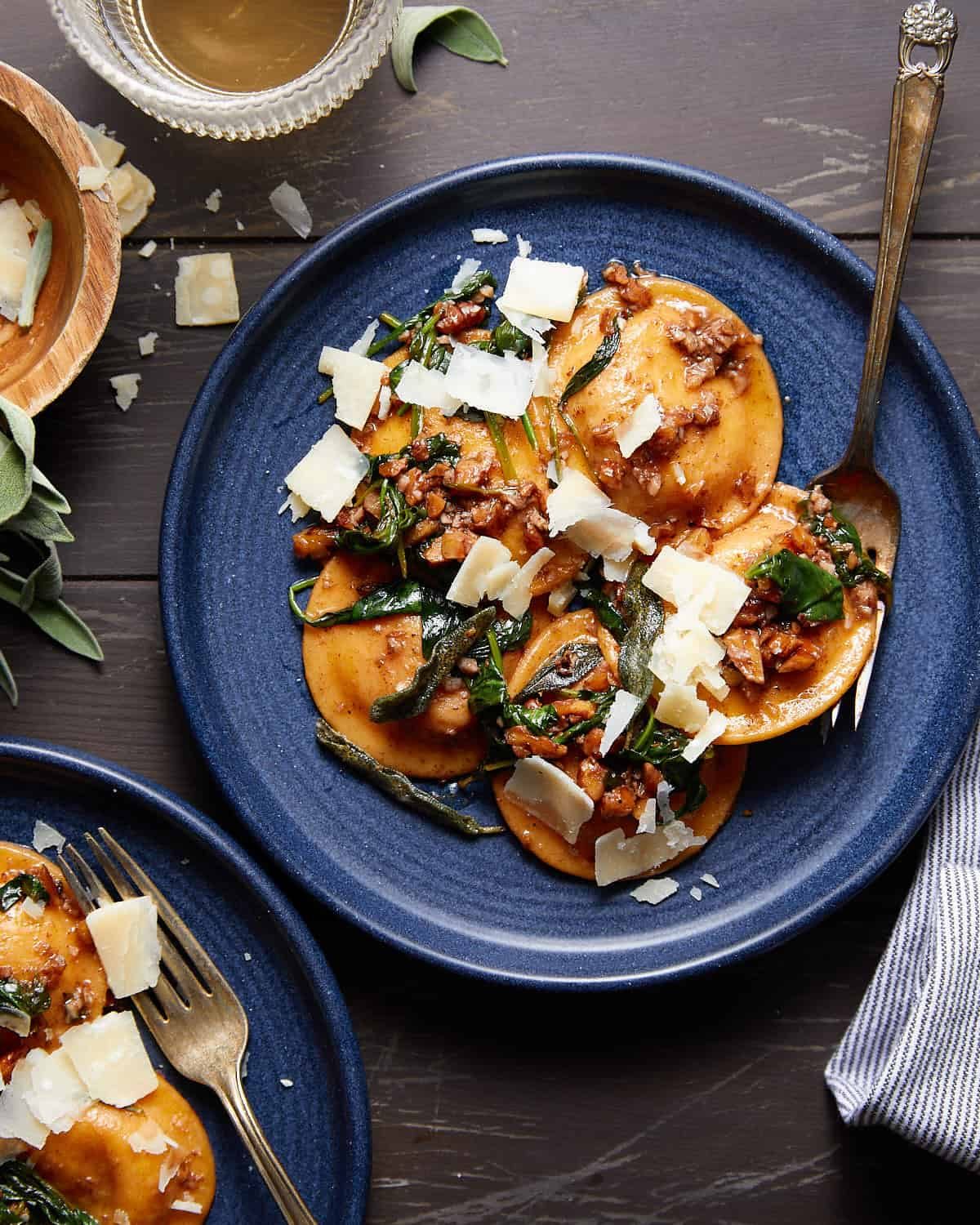 Overhead image of butternut squash ravioli sauce on blue dish.