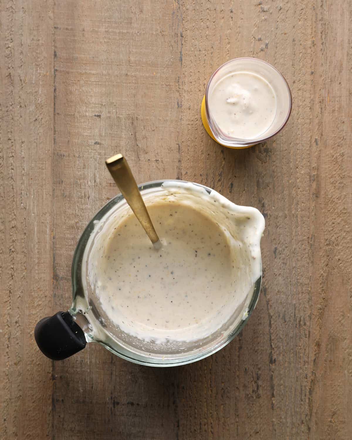 Caesar marinade ingredients mixed in a small bowl with a spoon.