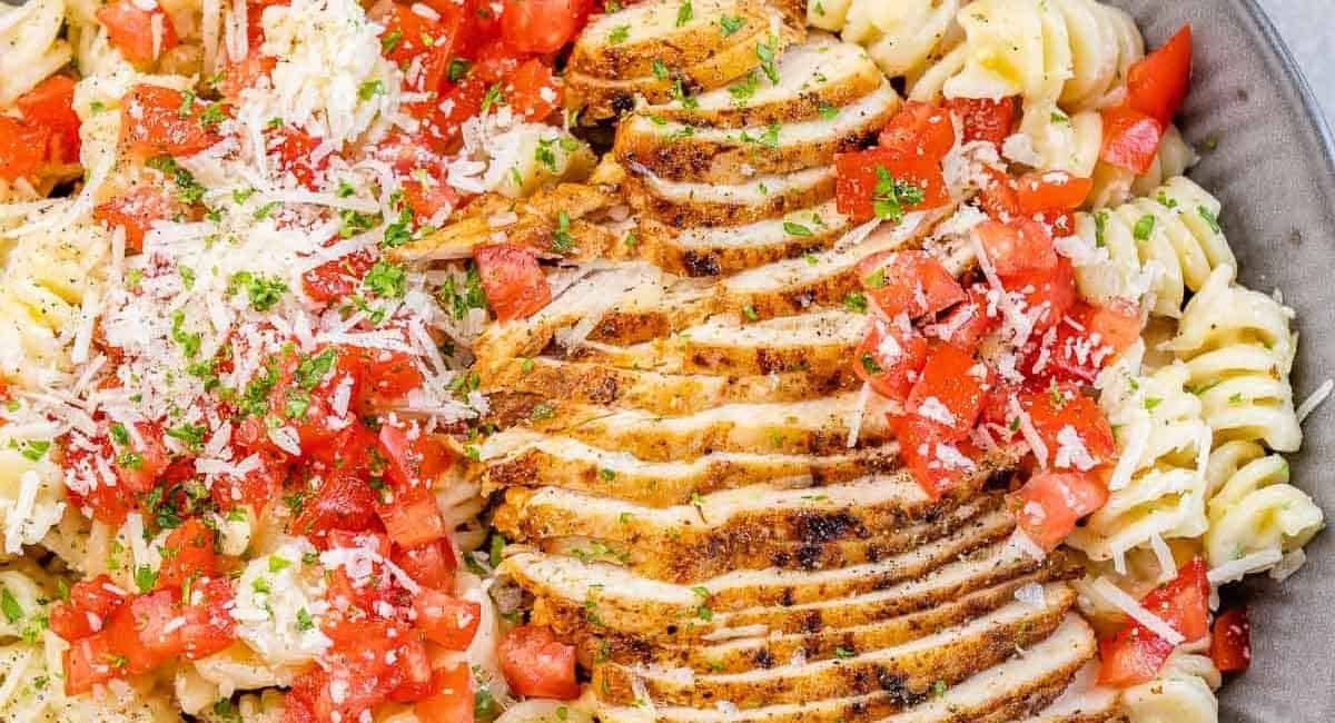 Overhead image of cajun chicken pasta with garnish.