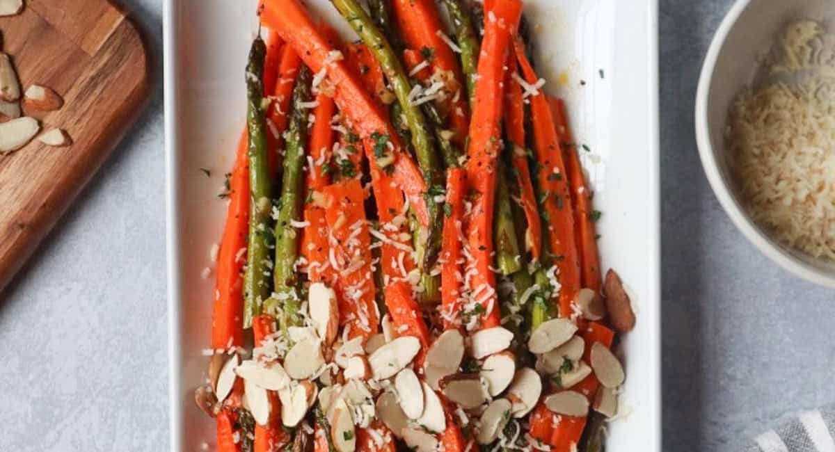 Overhead image of roasted carrots and asparagus with lemon dressing.