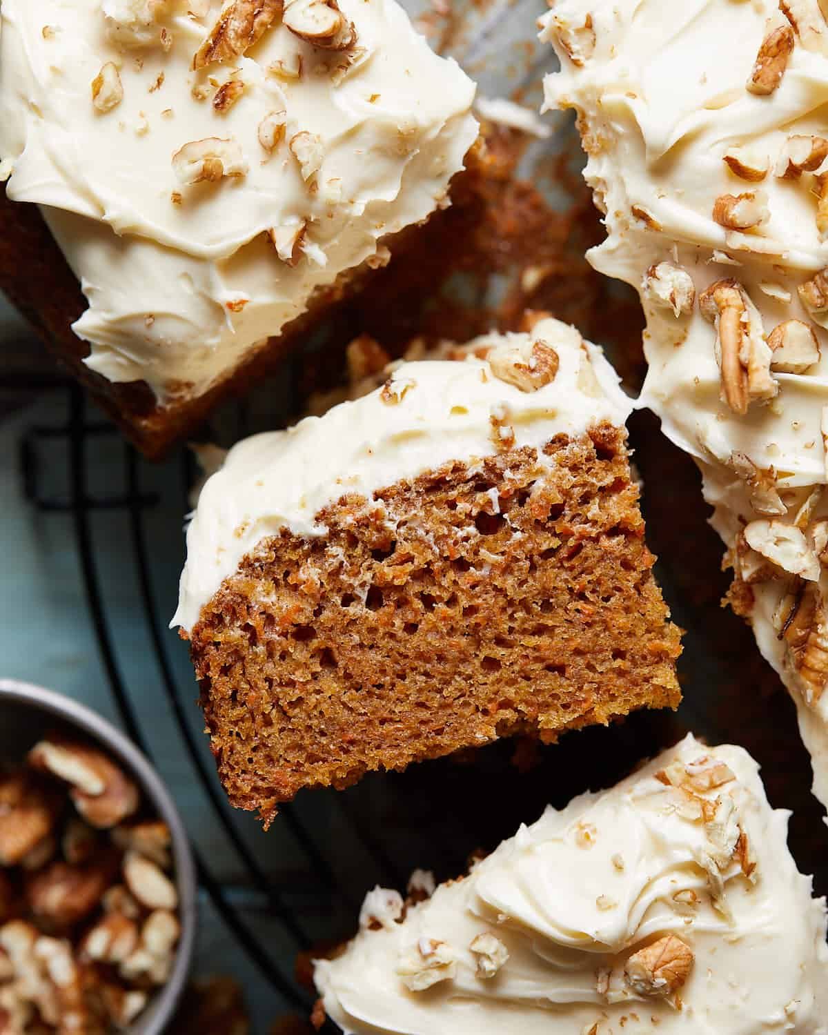 Up close image of carrot snack cake with frosting and garnish.