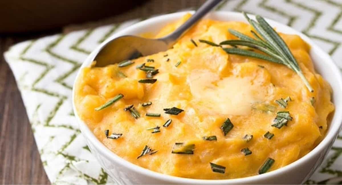 Up close image of cheddar pumpkin mashed potatoes with garnish.