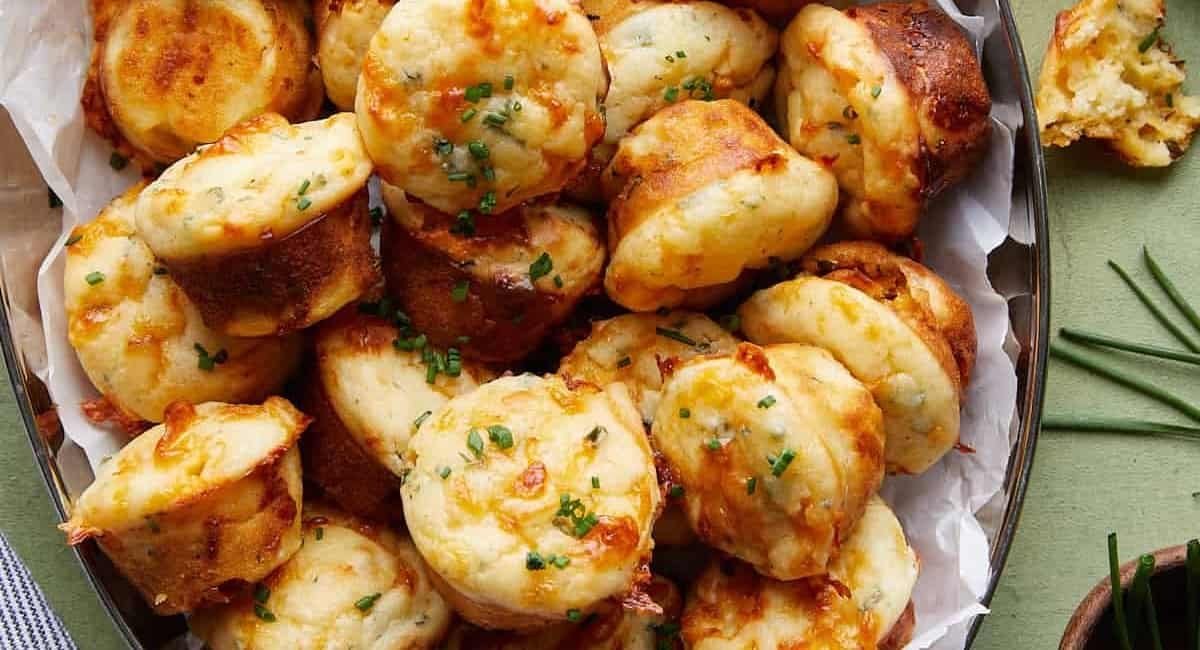 Overhead image of cheddar chive muffins with garnish.