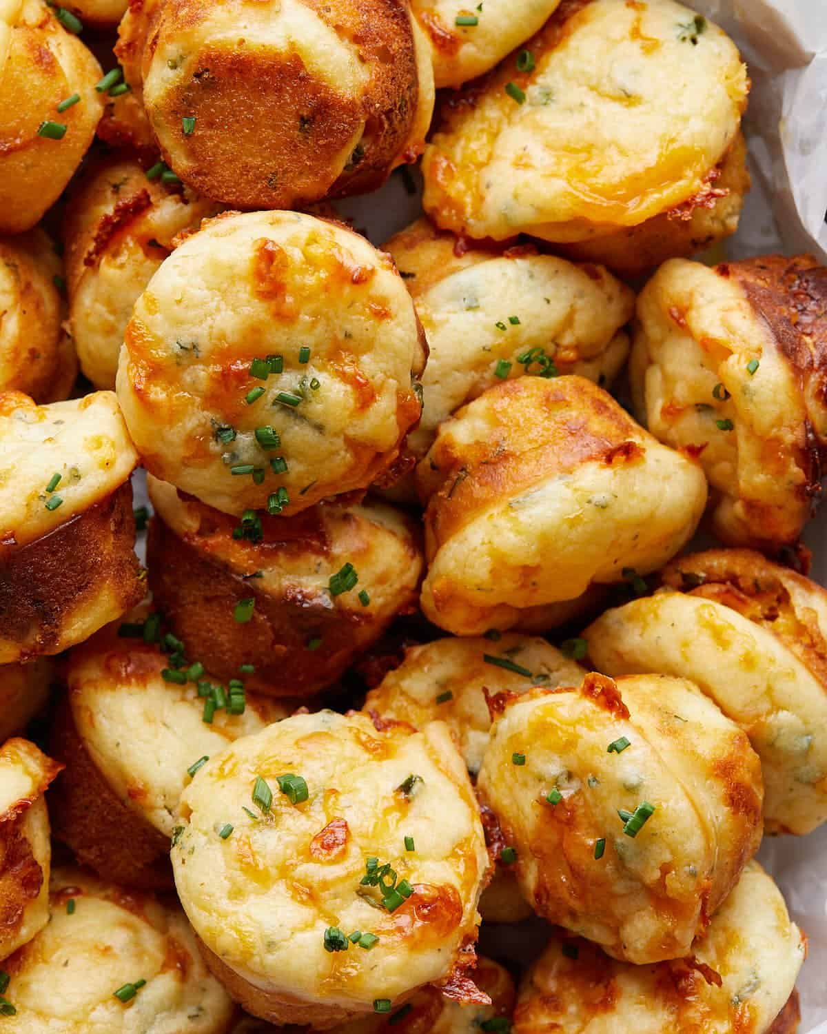 Up close image of cheddar chive muffins with garnish.