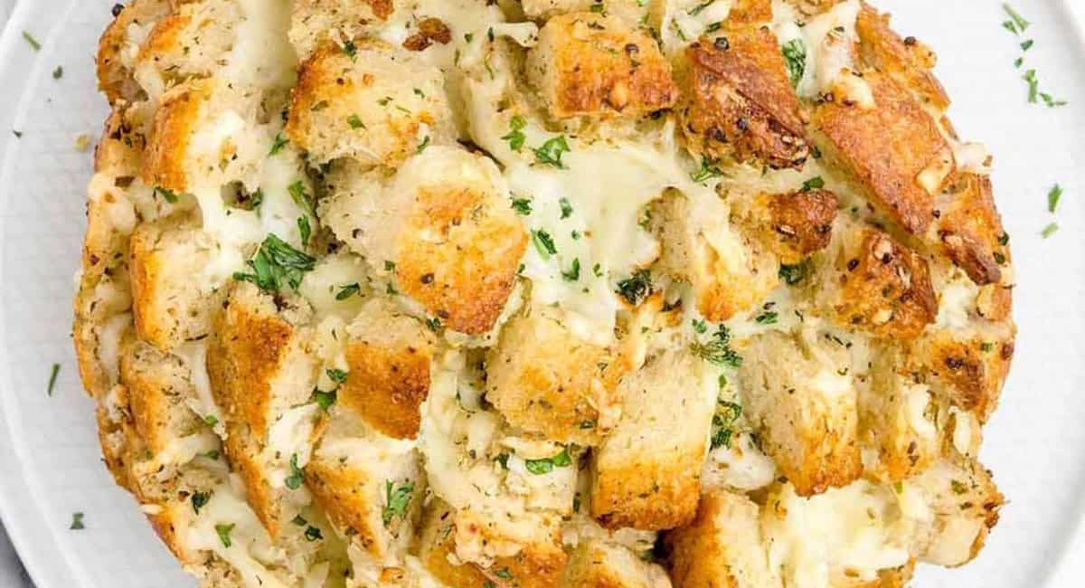 Overhead image of pull-apart garlic bread on white dish.