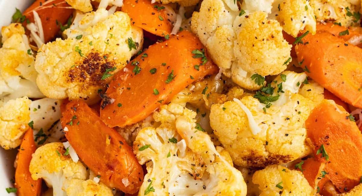 Up close image of cheesy roasted carrots and cauliflower.