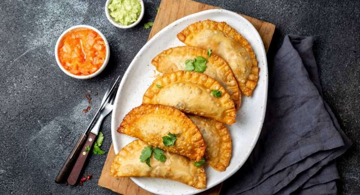Overhead image of chicken empanadas with garnish.