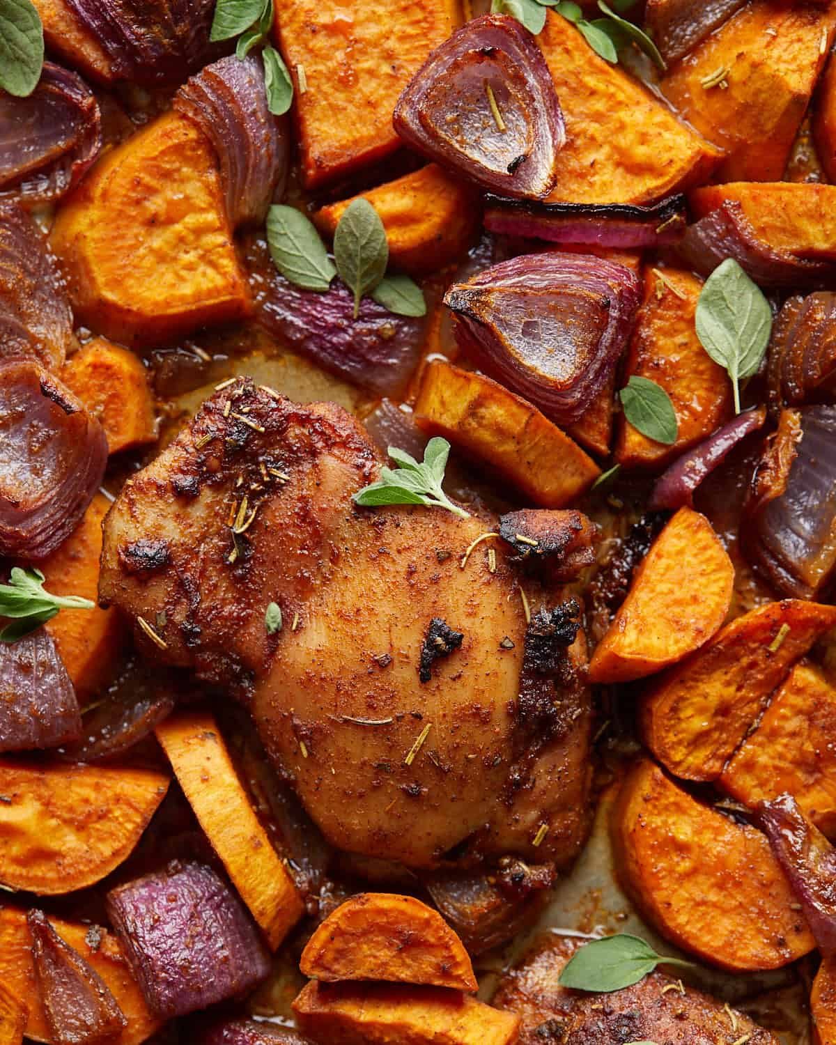 Up close overhead image of sheet pan chicken and sweet potatoes.