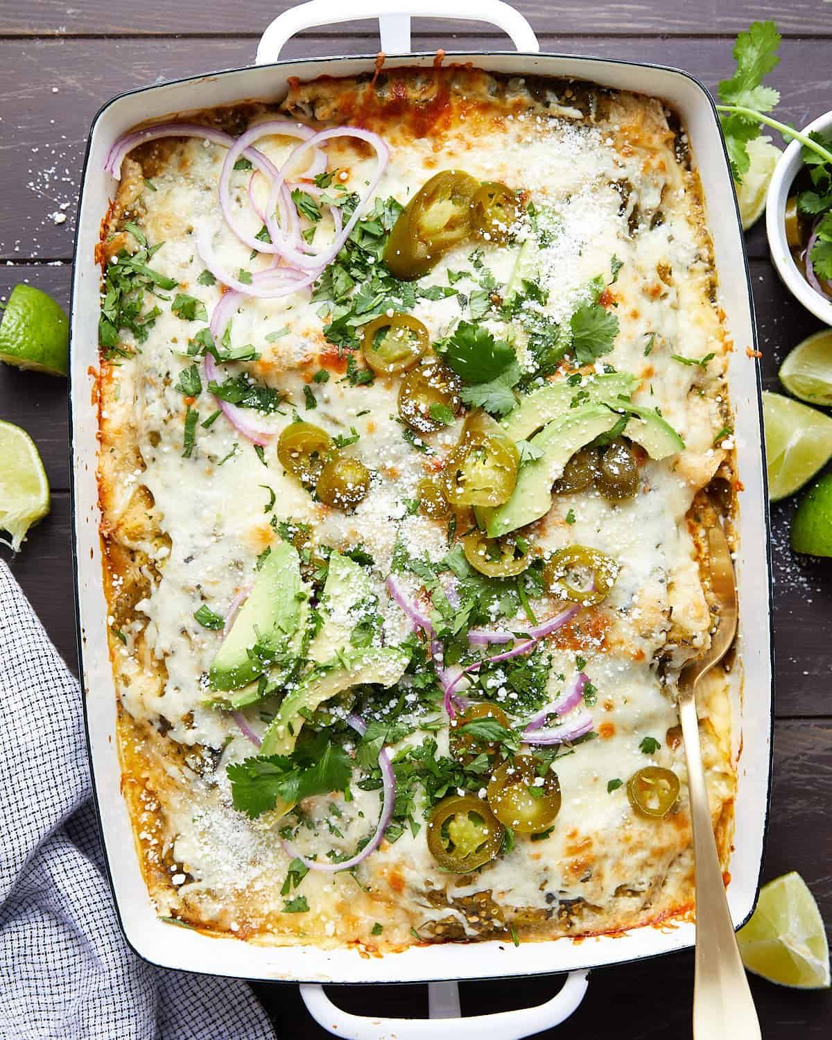 Overhead image of chicken enchiladas with green sauce.